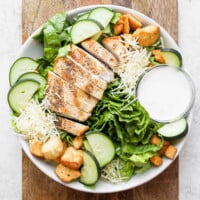 chicken salad with croutons and dressing in a white bowl.