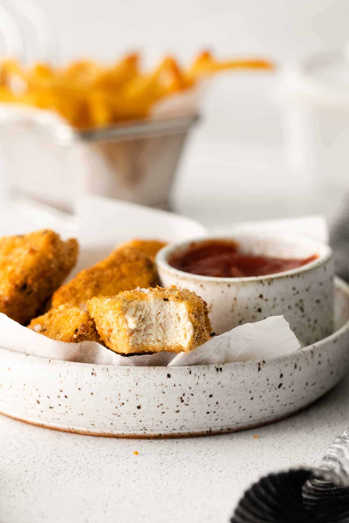 Air fryer chicken nuggets on a plate with BBQ sauce! 