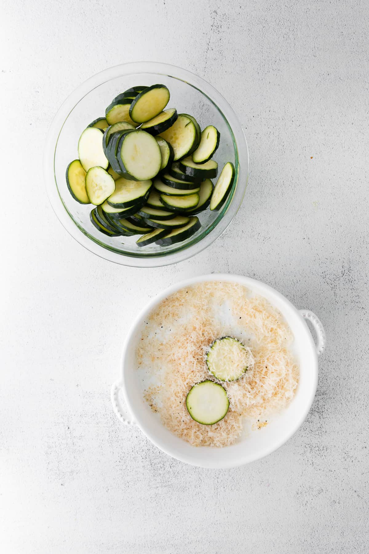 sliced zucchini dipped into parmesan coating before being placed in the air fryer.