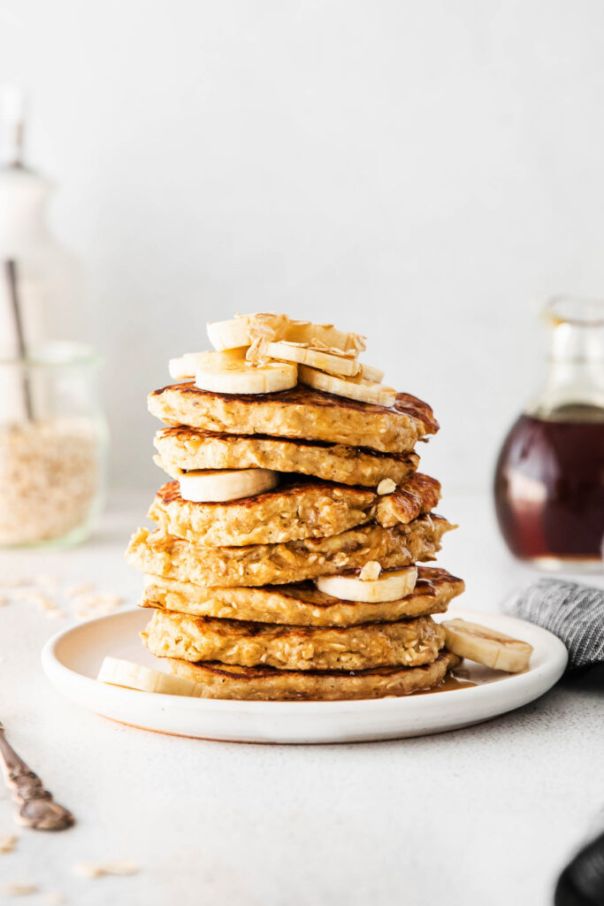 stack of pancakes with banana and oatmeal on top