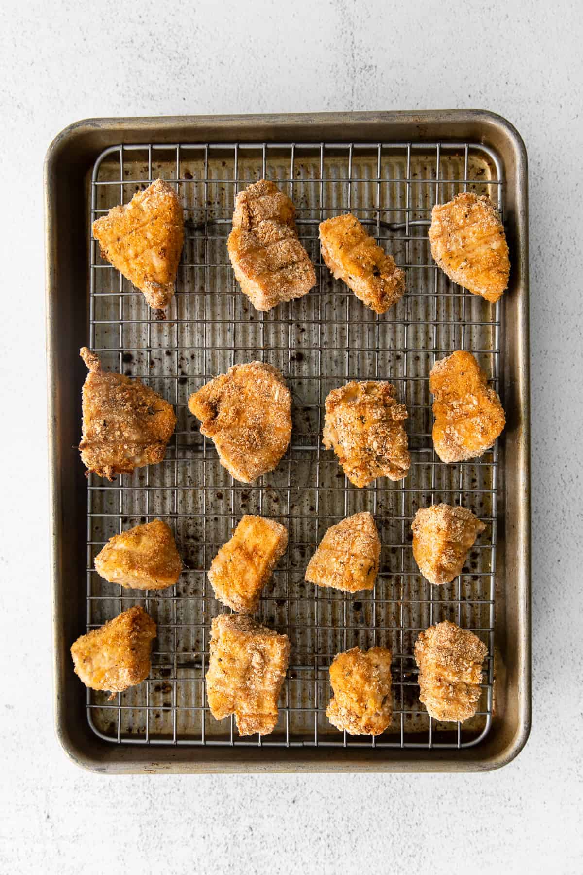 golden brown chicken nuggets on baking sheet