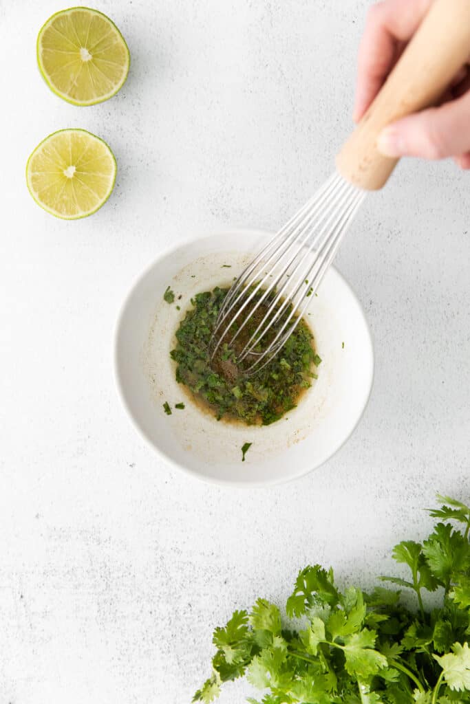easy cilantro lime dressing being whisked together in a bowl