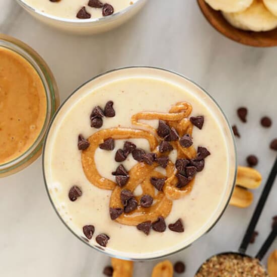 A bowl of peanut butter banana smoothie with chocolate chips and bananas.