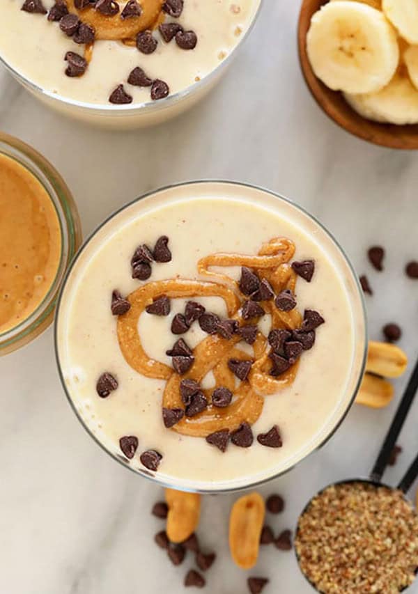 A bowl of peanut butter banana smoothie with chocolate chips and bananas.