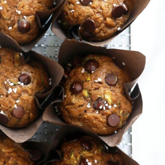 A tray of muffins with chocolate chips and pistachios.