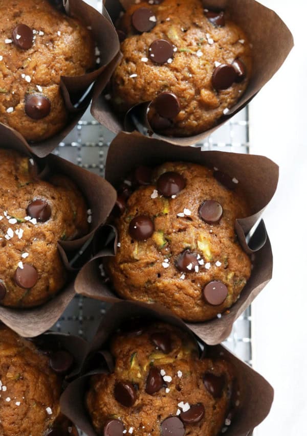 A tray of muffins with chocolate chips and pistachios.