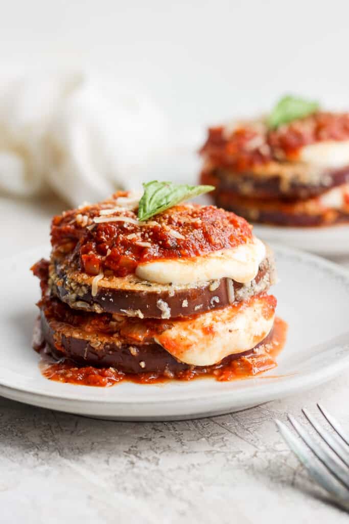 Eggplant parmesan plated and topped with fresh basil.