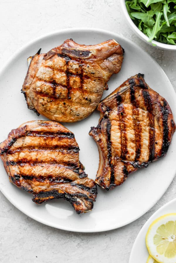 3 grilled pork chops on plate.