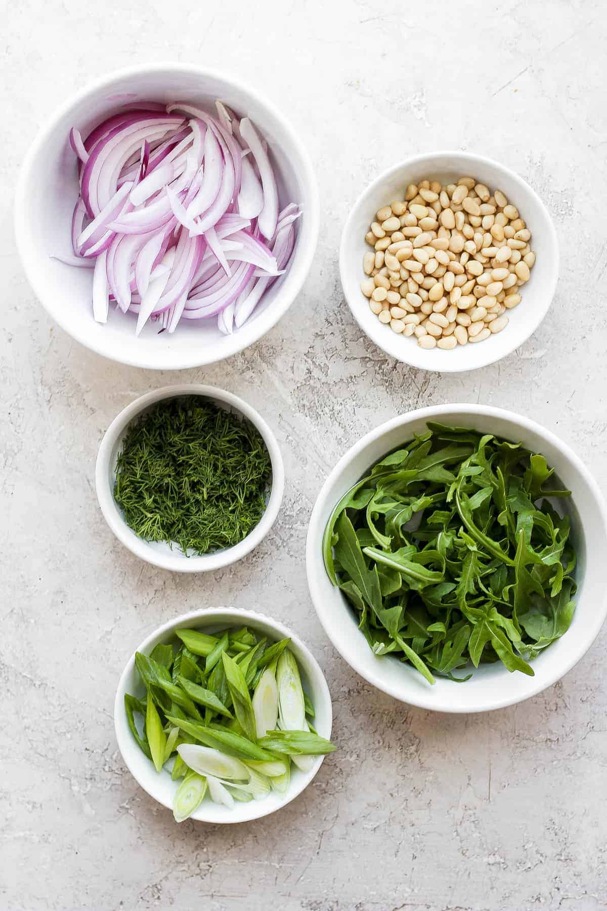 zucchini salad ingredients in bowls, ready to be tossed together