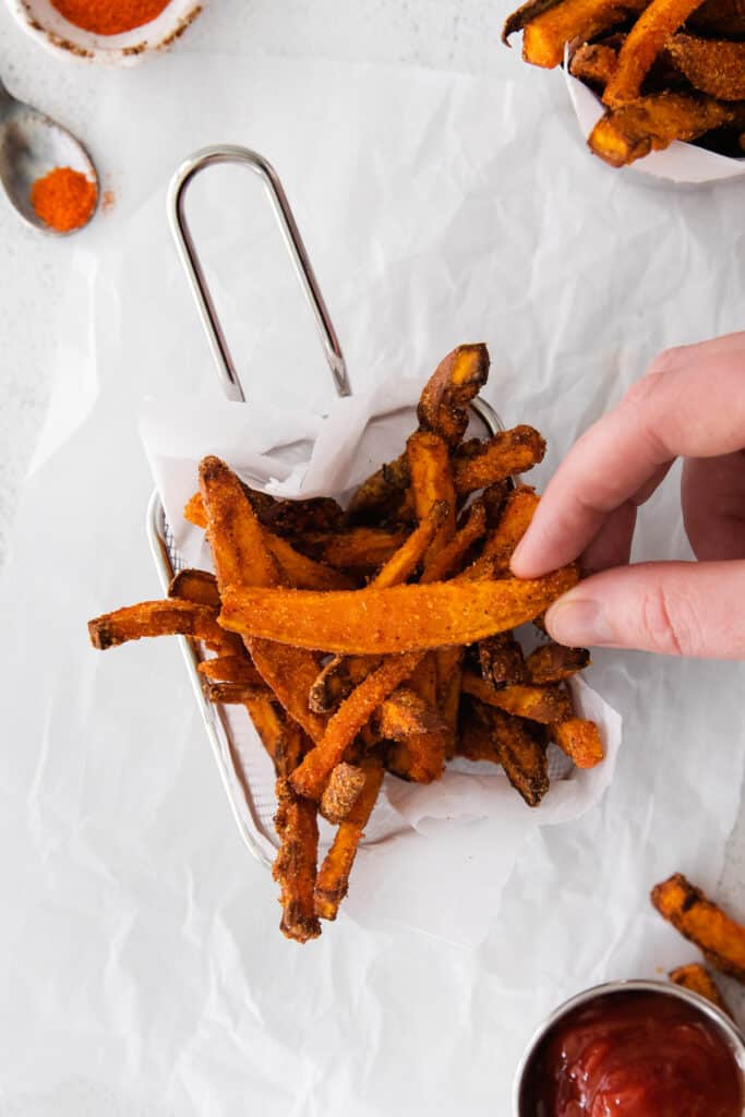 air fryer sweet potato fries in a fry basket ready to be served