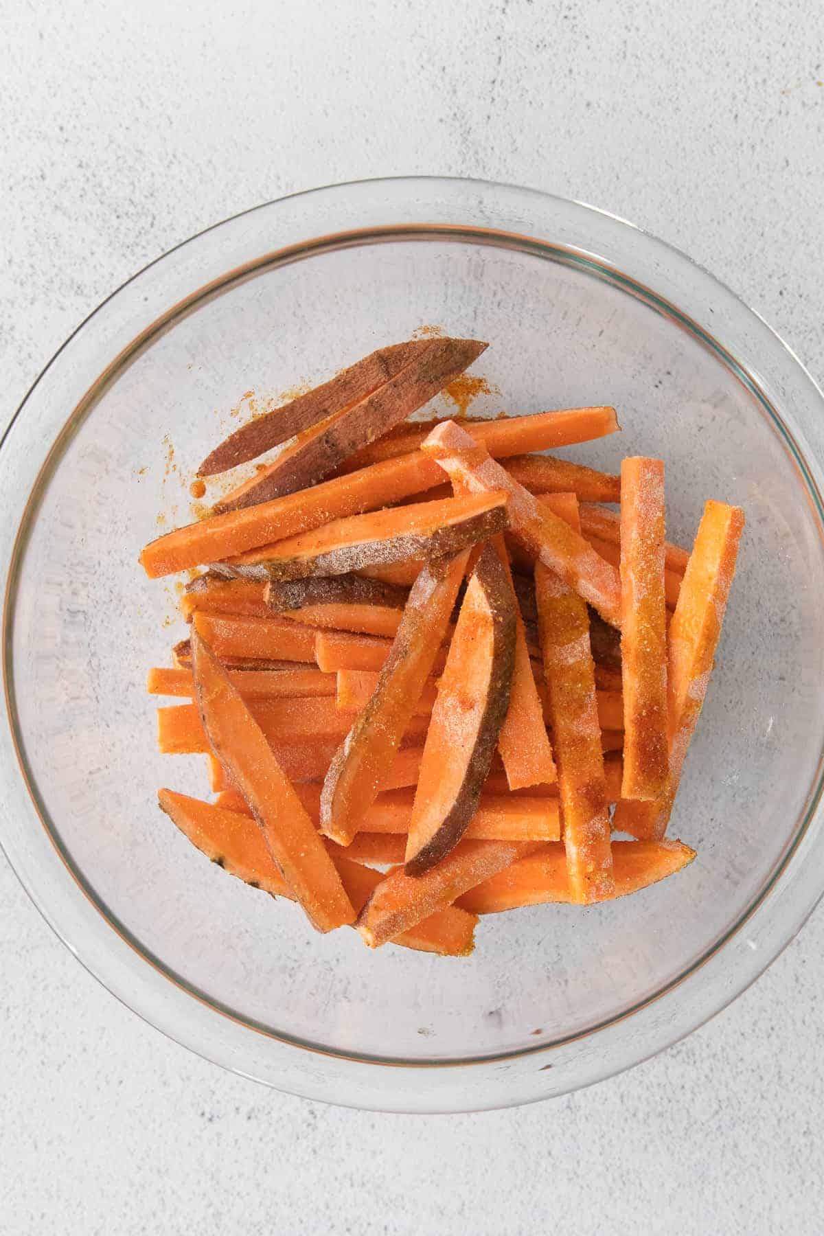 air fryer sweet potato fries in a bowl tossed with seasonings