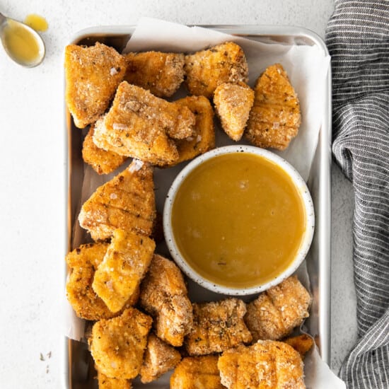 a tray of fried chicken nuggets and sauce.