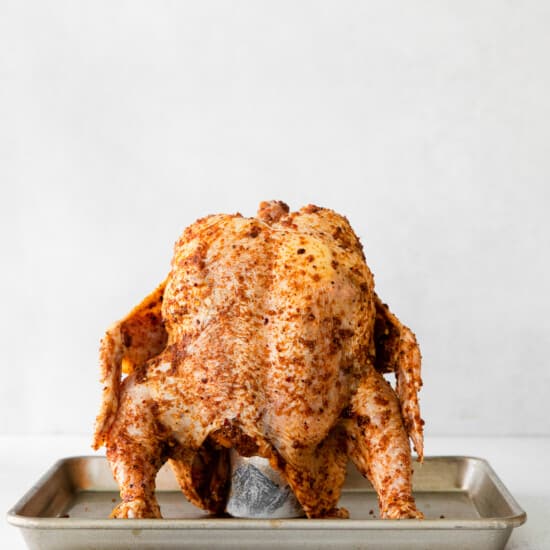 a beer can chicken roasting on a tray.