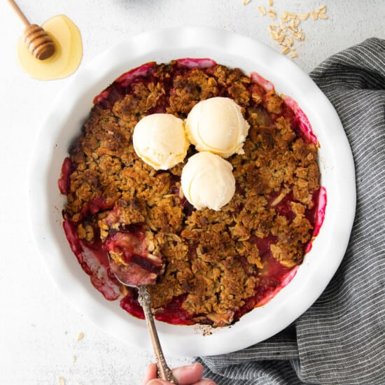 a bowl of raspberry crumble with a scoop of ice cream.