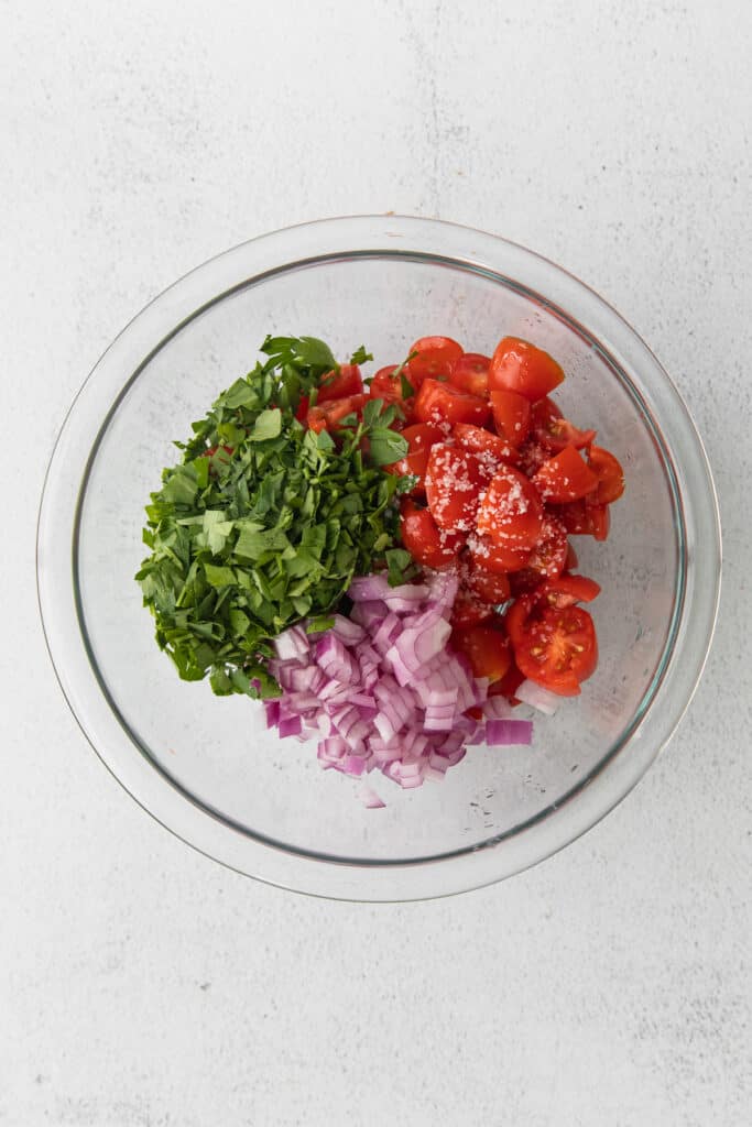 ingredients for tomato pico in a bowl, ready to be mixed together