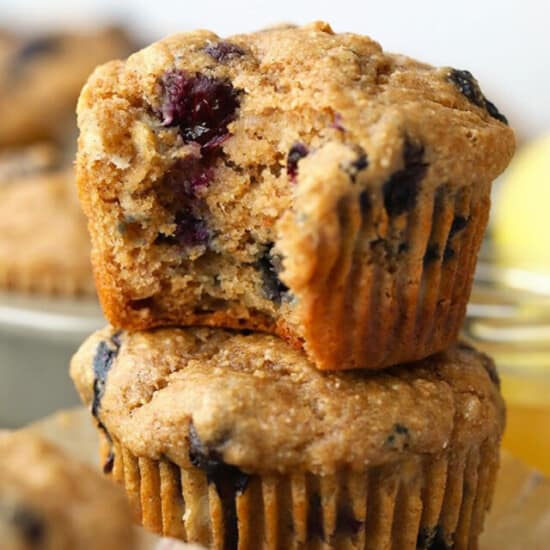 A stack of blueberry muffins with a bite taken out.