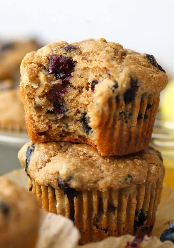 A stack of blueberry muffins with a bite taken out.