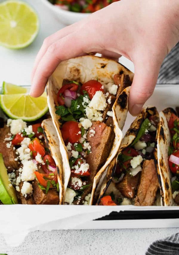 hand holding steak tacos