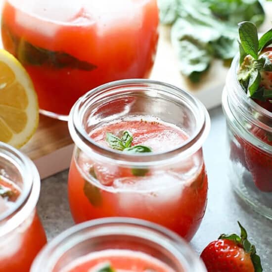Strawberry lemonade in jars with mint leaves.