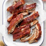 bbq ribs in a white dish with ketchup.