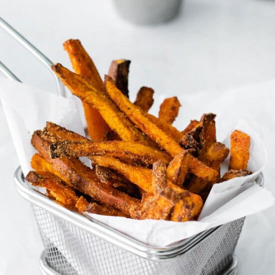 Air fried sweet potato fries served in a wire basket.