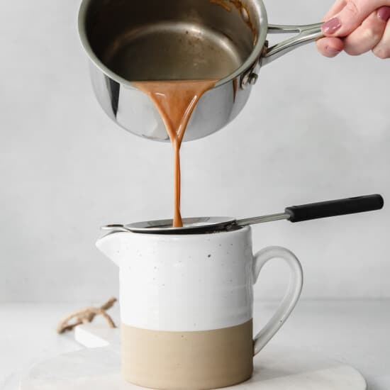 A person pouring caramel into a pot.