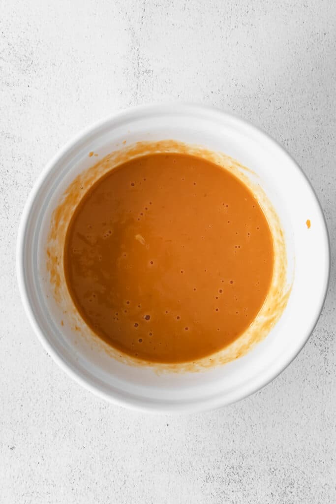 Wet ingredient for pumpkin bread mixed in a bowl. 
