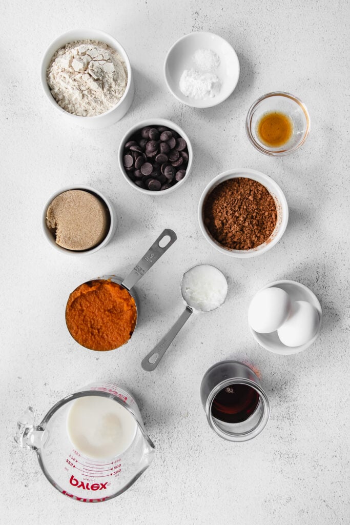 All the ingredients for pumpkin bread in small bowls. 