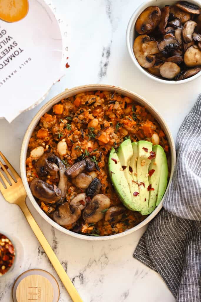harvest bowl topped with fresh avocado and sliced mushrooms