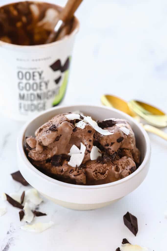 daily harvest ice cream in a bowl topped with coconut shreds and chunks of chocolate 