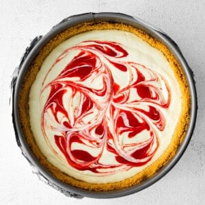 Greek yogurt cheesecake with red and white swirls on top.