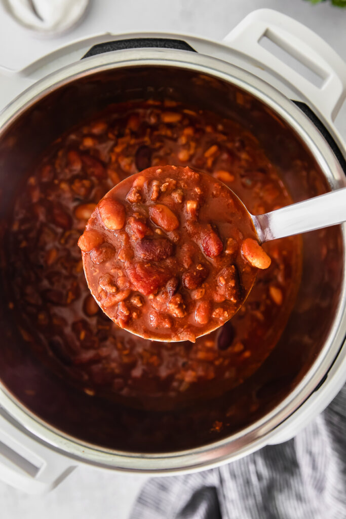 instant ، chili filling a ladle.