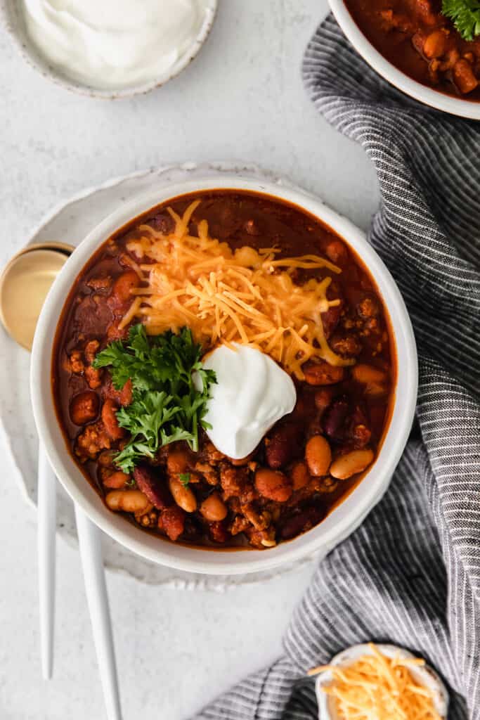 instant pot chili topped with shredded cheese in a bowl.