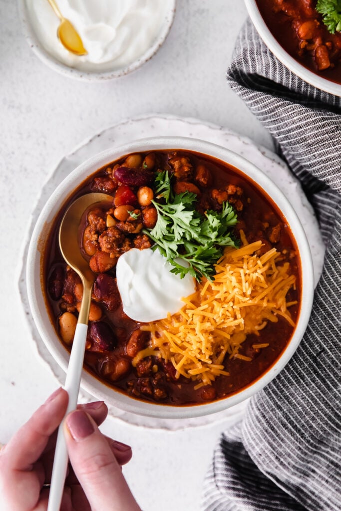 instant ، chili in a bowl topped with shredded cheese greek yogurt and fresh parsley.