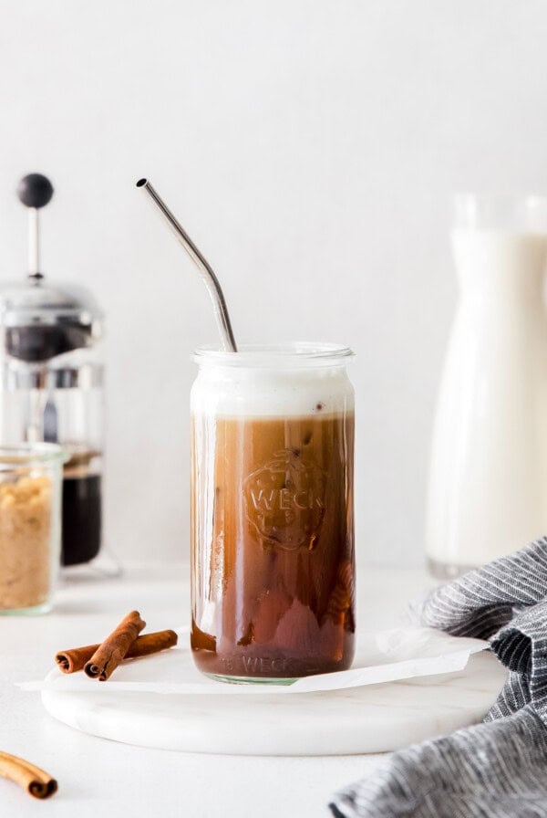 an iced coffee in a jar with cinnamon sticks.