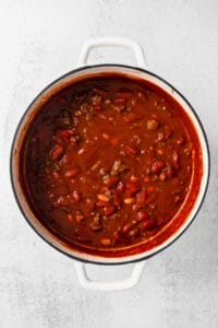 chili in a white pot on a white background.