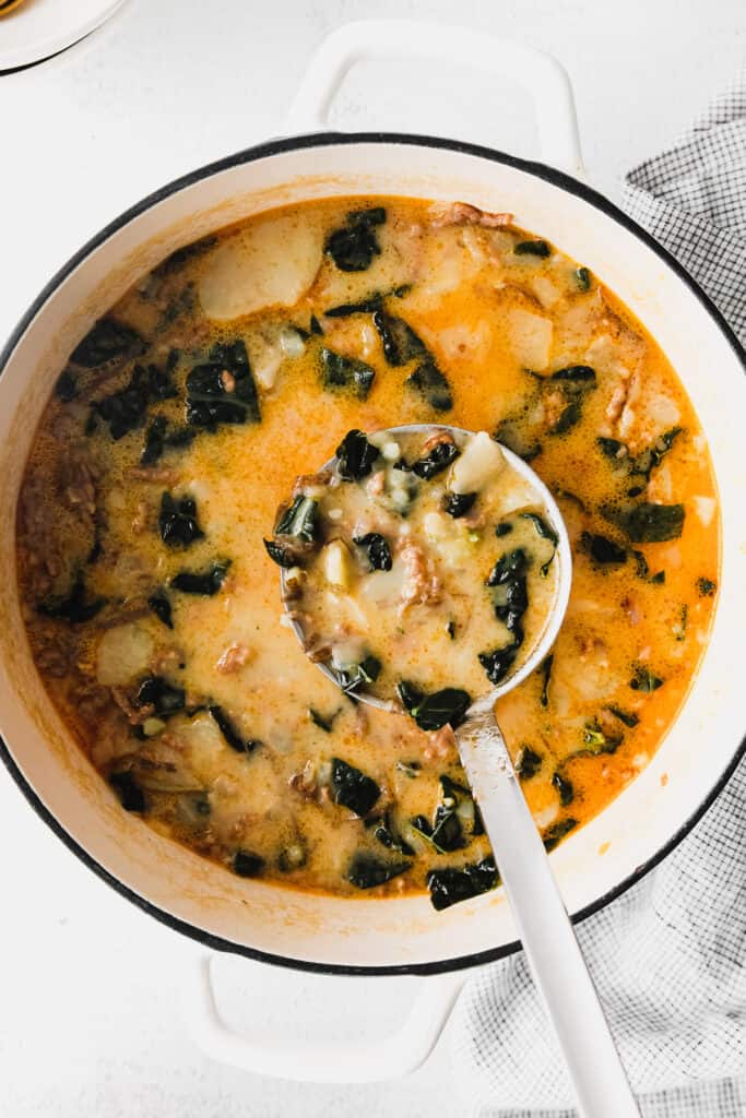 zuppa toscana soup in a stock pot with a ladle full of soup
