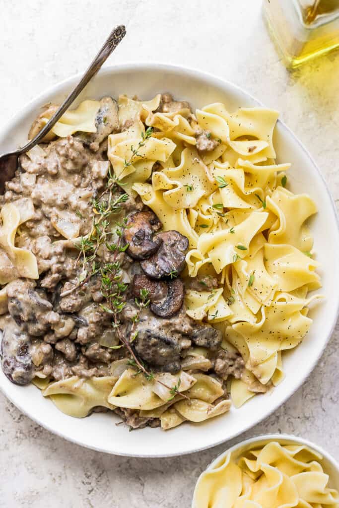 ground beef stroganoff in a bowl topped with fresh thyme