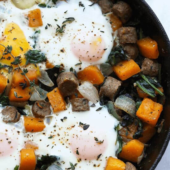 a skillet filled with eggs, squash, and herbs.