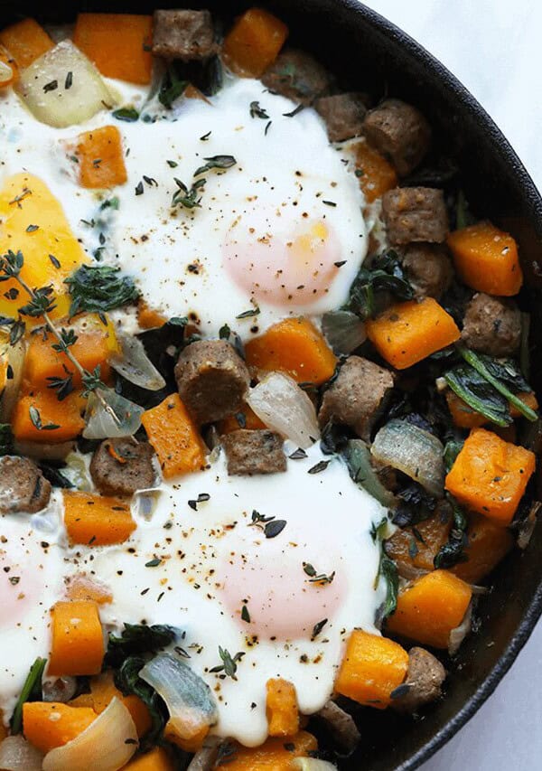 a skillet filled with eggs, squash, and herbs.