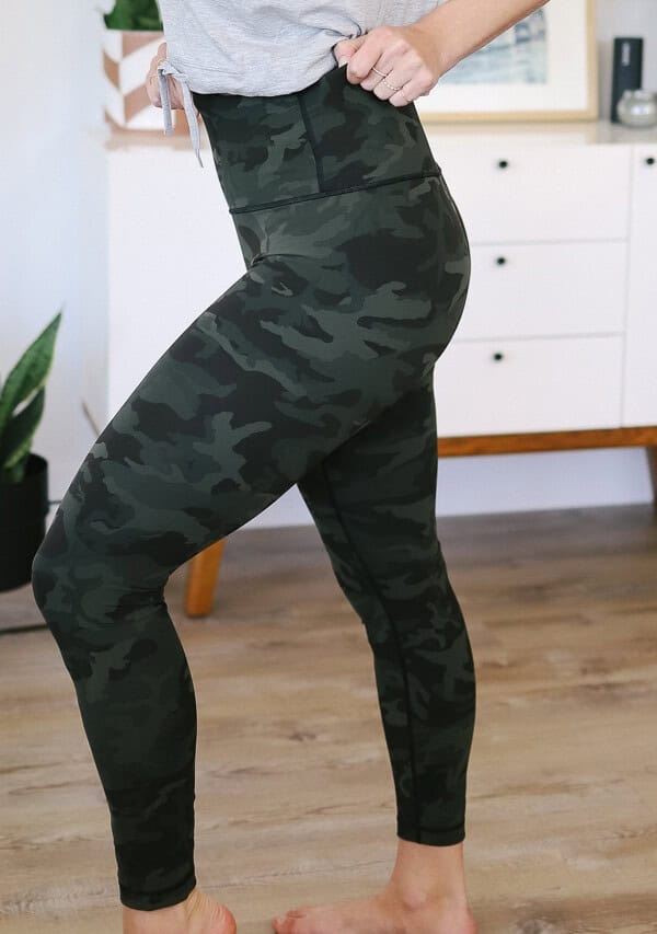 a woman wearing camouflage leggings in a living room.