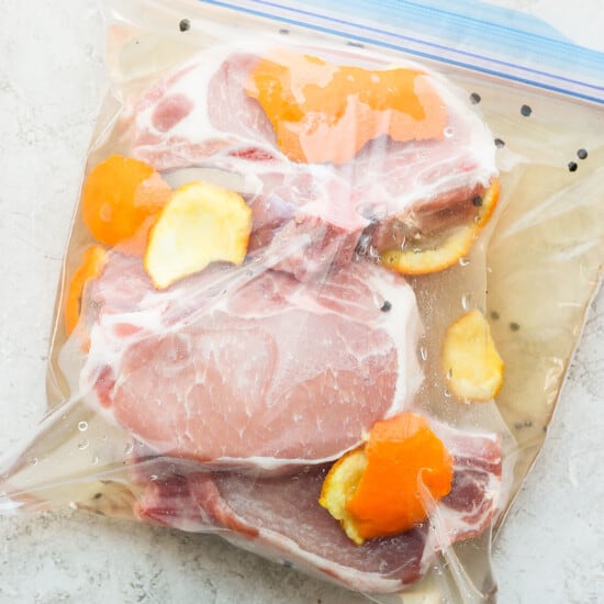 pork chops in a plastic bag with orange slices.