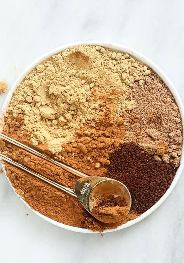 a white bowl filled with ingredients for a pumpkin spice latte.