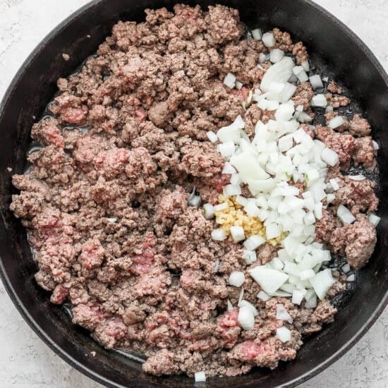Ground beef and onions cooked in a skillet with flavorful slow cooker chili spices.