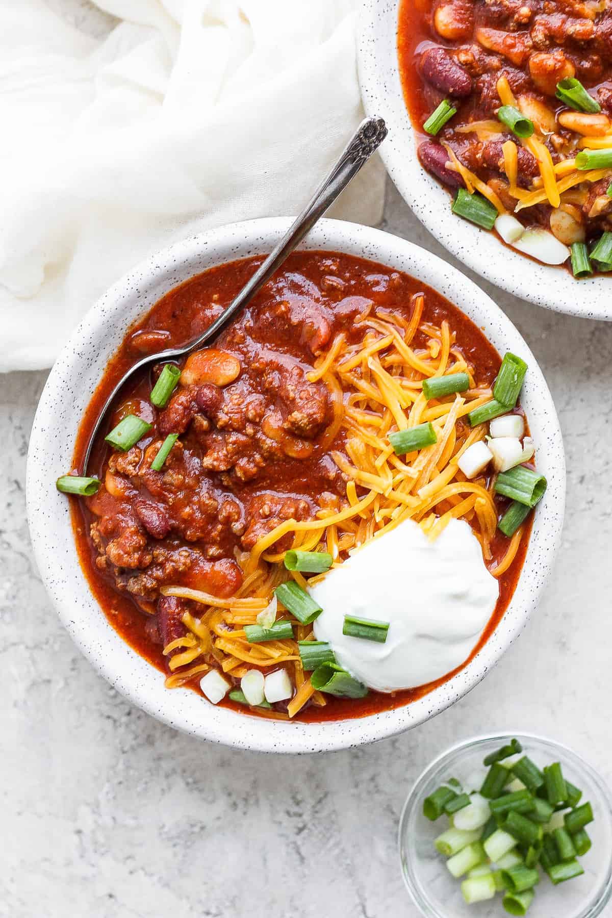 Slow cooker chili in a bowl with a spoon.