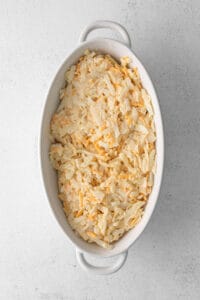 Shredded cabbage in a white dish on a white background.