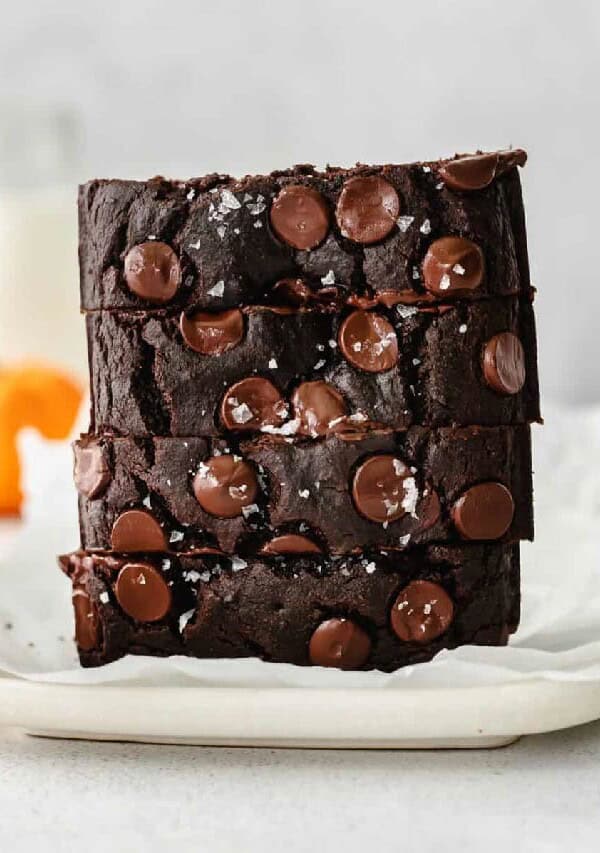 a stack of chocolate brownies on a white plate.