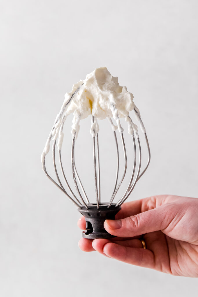 Whipped cream on a whisk attachment. 