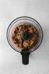 a food processor filled with a brown mixture.