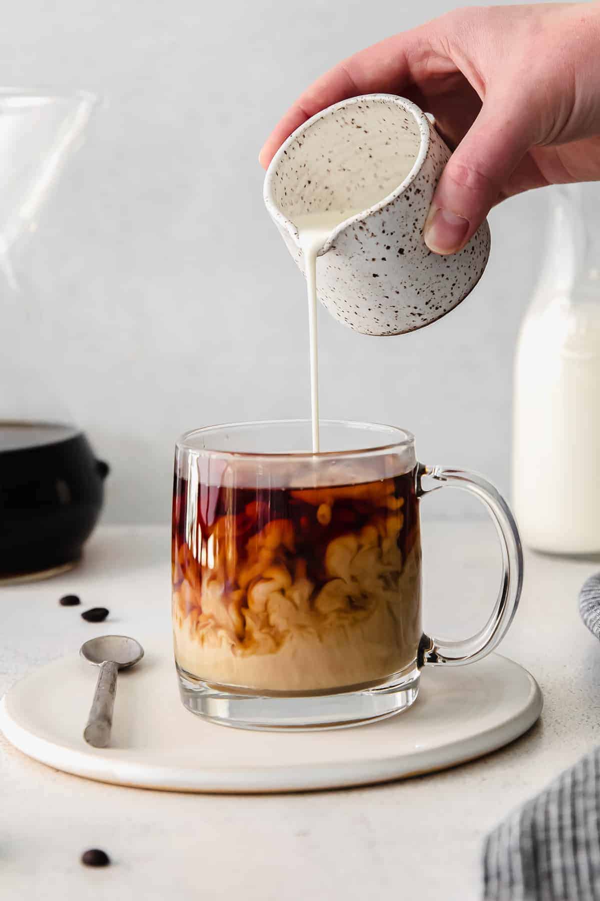 pouring cream into coffee